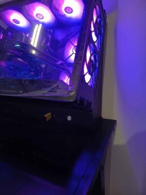 RGB éclairage et composants gaming dans un PC de bureau moderne, illuminated par des lumières LED violettes et bleues, montrant une configuration high-tech pour gaming ou streaming.